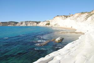 een rots in het water naast een strand bij Solemar in Giardina Gallotti