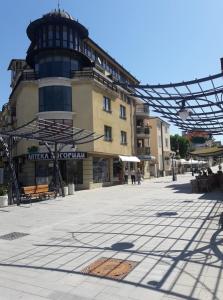 a building with a clock tower in the middle of a street at Bogorodi Terrace Apartment in Burgas