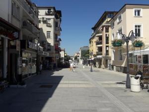 a street with buildings and people walking down a street at Bogorodi Terrace Apartment in Burgas