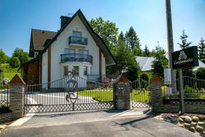 a house with a gate in front of it at Gordonówka Apartamenty & SPA in Szaflary