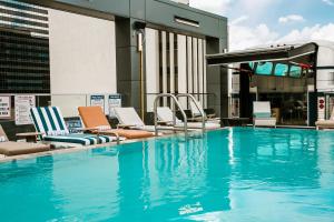 a swimming pool with lounge chairs on top of a building at Bobby Hotel in Nashville
