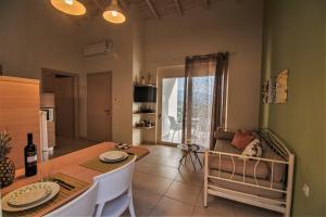 a kitchen and dining room with a table and a couch at Aksos Suites Accessible Accommodation in Ayiá