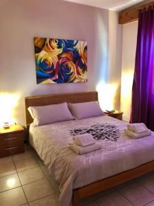 a bedroom with a bed with a painting on the wall at Appartamento Rosegarden in Pescantina
