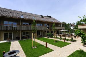 a building with a courtyard with tables and trees at Bernhardhof Andechs in Andechs