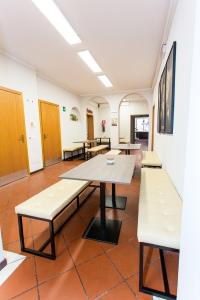 Student's Hostel Estense في فيرّارا: غرفة فارغة مع طاولات وكراسي