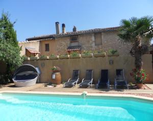 ein Haus mit Stühlen und einem Pool in der Unterkunft Maison de Vacances "Gîte Ivana" avec piscine privée chauffée in Oppède