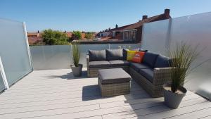 een patio met een bank en stoelen op een balkon bij ZON ZEE STRAND Bed by the Sea in Westkapelle