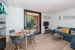 a living room with a table and a blue couch at L'Ophélie in Six-Fours-les-Plages