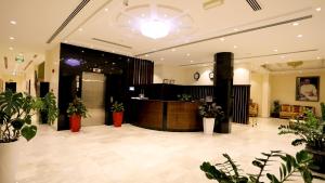 a lobby with a reception desk and potted plants at Remas Hotel Suites - Al Khoudh, Seeb, Muscat in Seeb
