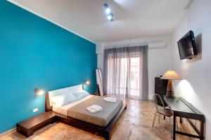 a bedroom with a bed and a blue wall at BUTTERFLY B&B in Lecce