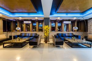 7Q Patong Beach Hotel في شاطيء باتونغ: مطعم فيه اضاءة زرقاء وطاولات وكراسي