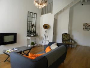 a living room with a blue couch and a tv at Le jardin des chanceliers in Beaune