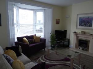 ポートランドにあるCornerstoneの紫色のソファと暖炉付きのリビングルーム