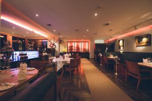 a restaurant with tables and chairs in a room at Das Wildeck Hotel & Restaurant in Abstatt