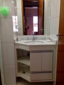 uma casa de banho com um lavatório e um espelho em Apartamento Ubatuba-Itaguá em Ubatuba