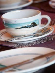 una taza y platillos sentados sobre una mesa en Golf Lodge Bed & Breakfast, en North Berwick