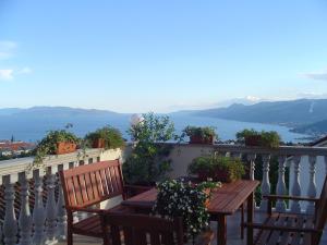 uma varanda com 2 mesas e cadeiras de madeira e uma vista em Apartments Villa Kastav em Kastav