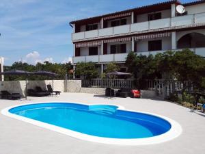 a swimming pool in front of a building at Guesthouse Marija in Lopar