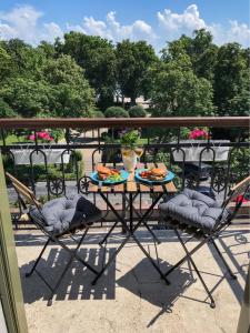 uma mesa e cadeiras com comida numa varanda em Balkon Apartman Horváth Ház Balatonfüred em Balatonfüred