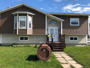 a house with a sign in front of it at Aggie's B&B in Bonavista