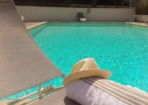 a hat sitting on a chair next to a swimming pool at Hotel Villa Catarie in Gu&eacute;thary