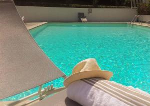a hat sitting on a chair next to a swimming pool at Hotel Villa Catarie in Guéthary