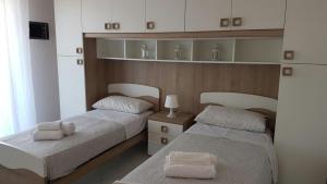 A bed or beds in a room at DOMUS MARIS Viserba, Spiagge e Centro a 100 mt, PROMO MAGGIO FIERA MACFRUT, FIERAVICOLA, EXPO DENTAL, MEETING RIMINI