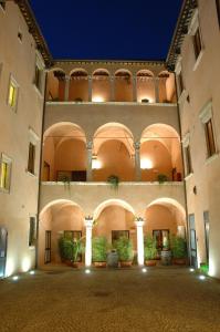 ein großes Gebäude mit einem Innenhof mit Topfpflanzen in der Unterkunft Palazzo Guiderocchi in Ascoli Piceno
