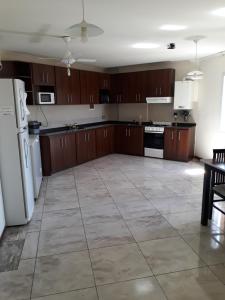 a large kitchen with brown cabinets and white appliances at Departamento in Villa Carlos Paz