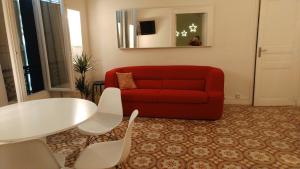 a living room with a red couch and a table at Vintage Vieux-Port Apartment in Marseille