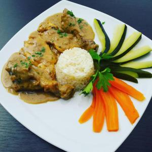 un plato blanco de comida con arroz y verduras en Hotel Mojito en Domaso