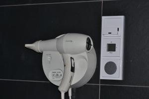 a hair dryer is attached to a bathroom wall at Auberge De Moerse Hoeve in De Moer