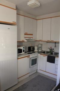 a kitchen with white cabinets and white appliances at Visit Hautakylä in Hautakylä