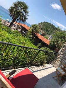 einen Balkon mit Blick auf das Meer und eine Palme in der Unterkunft Sea forever in Petrovac na Moru