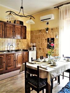 een keuken met een tafel met stoelen en een wastafel bij Il Tuo Letto Sullo Stretto in Reggio di Calabria