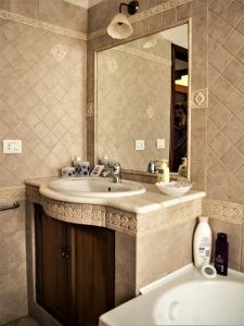 La salle de bains est pourvue d'un lavabo, d'un miroir et d'une baignoire. dans l'établissement Il Tuo Letto Sullo Stretto, à Reggio de Calabre