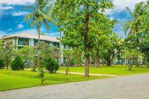 a house in a park with palm trees at Fresco Water Villa in Sigiriya