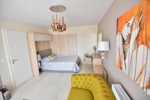 a bedroom with a bed and a yellow couch at Your Home at Coresi Mall in Braşov