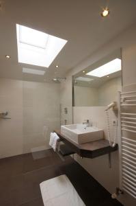 baño con lavabo y espejo grande en Appartementhaus Nadine, en Längenfeld