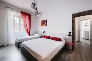 1 dormitorio con 2 camas y cortina roja en Lele Rooms San Lorenzo en Roma