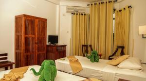 a bedroom with two beds with stuffed animals on them at Senani Hotel in Kandy