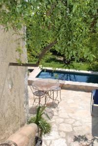 eine Terrasse mit einem Tisch und Stühlen neben einem Pool in der Unterkunft Les Orangers in Saint-Paul-de-Vence