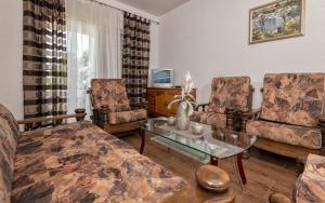 ein Wohnzimmer mit 2 Stühlen und einem Tisch in der Unterkunft Tea Apartman in Neum