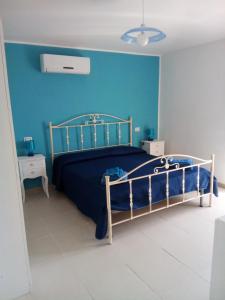 a bedroom with a bed with a blue wall at Astonishing Calabria pet friendly apts in Santa Caterina dello Ionio