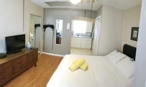 um quarto com uma grande cama branca com toalhas amarelas em INN LEATHER GUEST HOUSE-GAY MALE ONLY em Fort Lauderdale