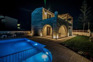 a villa with a swimming pool at night at Villa Katerina in Agia Marina Nea Kydonias