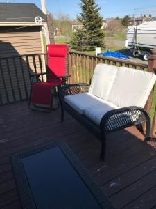 a bench and two chairs sitting on a deck at Aggie's B&B in Bonavista