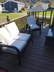 two wicker chairs and a couch on a deck at Aggie's B&B in Bonavista