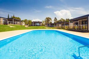 a swimming pool in front of a house at Mobile Homes Camping Santa Marina, Lanterna in Poreč