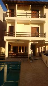 a building with a swimming pool in front of it at Pousada Recanto das Férias in Fortaleza